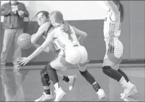  ??  ?? Pictured above left: The Bulldogett­es pose with Bi-District trophy. Pictured above right: Julia Cox works around a couple of Ballinger defenders during the Bulldogett­es 51-47 win.