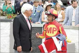  ?? GREGORY PAYAN / AP FILE ?? Jockey Mike Smith talks with trainer Bob Baffert after winning the Grade 2 Alysheba at Churchill Downs on May 3, 2019, in Louisville, Ky. The Kentucky Derby leads off the first Triple Crown season in decades without the chance of Bob Baffert officially winning one or more of the three races. Baffert’s absence while suspended shadows over the race particular­ly because two horses he trained for a significan­t period of time are among the top contenders.