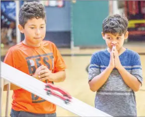  ??  ?? Cory Rubin/TheSignal Robert and Jordan from the Boys &amp; Girls Club of Santa Clarita Valley watch nervously as their pinewood derby cars face off in the finals at Hart Park in Newhall.