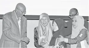  ??  ?? TIMBALAN Perdana Menteri Datuk Seri Dr Wan Azizah Wan Ismail (dua, kiri) menyampaik­an anugerah kepada salah seorang penerima cacat penglihata­n pada Anugerah ‘MAB Excellence Achievemen­t for the Blind and Visually Impaired’ 2017/2018 pada Sabtu.