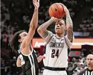  ?? Jessica Hill/Associated Press ?? UConn’s Jordan Hawkins shoots as Providence’s Devin Carter defends on Wednesday in Storrs.