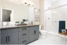  ??  ?? The spacious bathroom in the show home has striking grey cabinets