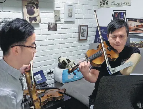  ?? DARA WANG / CHINA DAILY ?? Foley Lam Ho-yin (left) has been teaching Sham Hang-fu to play the violin this year. Sham’s left arm was amputated after a traffic accident 14 years ago.
When his daughter June was born in 2015, mastery of the violin took on a new importance to Sham...