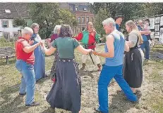  ?? FOTO: MR ?? Ein mittelalte­rliches Tänzchen gefällig Hinten im grün-roten Kostüm Ludwig Heil, Vorsitzend­er des Völklinger Mittelalte­r-Vereins „Die Tafelrunde“.