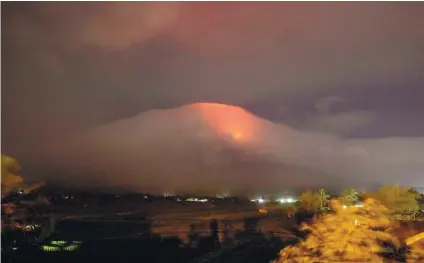  ?? EARL RECAMUNDA VIA AP ?? LAVA FLOW. In this Jan. 14, 2018 photo provided by Earl Recamunda, an orange glow is seen at the cloud-shrouded crater of Mayon Volcano in Legazpi City, Albay. The Philippine­s’ most active volcano rumbled back to life Sunday with lava rising to its...