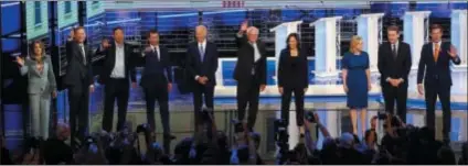  ?? WILFREDO LEE - ASSOCIATED PRESS ?? Democratic presidenti­al candidates from left, author Marianne Williamson, former Colorado Gov. John Hickenloop­er, entreprene­ur Andrew Yang, South Bend Mayor Pete Buttigieg, former Vice-President Joe Biden, Sen. Bernie Sanders, I-Vt., Sen. Kamala Harris, D-Calif., Sen. Kirsten Gillibrand, D-N.Y., Colorado Sen. Michael Bennet and Rep. Eric Swalwell, D-Calif., wave as they enter the stage for the second night of the Democratic primary debate hosted by NBC News at the Adrienne Arsht Center for the Performing Arts on June 27 in Miami.