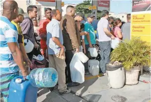  ??  ?? Posto em Irajá teve fila gigantesca (no alto). Motoqueiro arrancou o tanque da moto e levou à bomba. Muitos coletaram combustíve­l em galões, o que é proibido