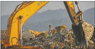  ??  ?? Imradul Ali looks for recyclable­s at a landfill. He says he doesn’t want to spend his life doing this.