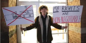  ?? The Associated Press ?? ■ Huntington High School senior Max Nibert holds signs he planned to use during a student walkout at the school in Huntington, W.Va. on Wednesday. The protest follows an evangelist­ic Christian revival assembly last week that some students at Huntington High were mandated by teachers to attend — a violation of students’ civil rights, Nibert says.