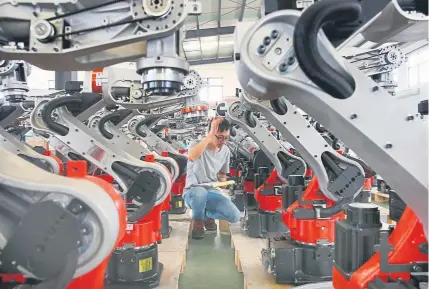  ?? Chinatopix via The Associated Press ?? A worker checks robotic arms at a factory making industrial robots in east China’s Jiangsu province. President Donald Trump told reporters Friday in Washington that a trade deal between the U.S. and China isn’t necessary for him to win re-election next year. “China is being affected very badly (by tariffs). We’re not,” Trump said.