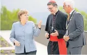  ?? FOTO: DPA ?? Bundeskanz­lerin Angela Merkel (CDU), Rainer Maria Kardinal Woelki (M.), Erzbischof von Köln, und der Siegburger Bürgermeis­ter Franz Huhn (CDU) unterhalte­n sich vor dem Festakt.