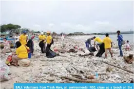  ?? — Reuters ?? BALI: Volunteers from Trash Hero, an environmen­tal NGO, clean up a beach on the island of Bali, Indonesia.