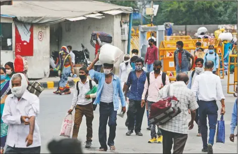  ?? (AP/Manish Swarup) ?? Migrant workers return with their belongings to look for work in New Delhi, India.