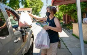  ??  ?? Nancy Emerick, of West View, hands out lunches as part of North Hills Cares, a nonprofit founded by North Hills parents to help kids in need.