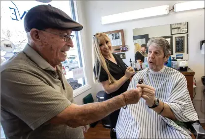  ?? PHOTOS BY KARL MONDON — STAFF PHOTOGRAPH­ER ?? Retired barber Gabe Gonzales, 96, surprises customer Sean O'Kane with a lollipop Thursday.
