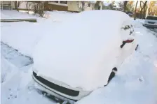  ?? BRENDAN MILLER ?? A car sits buried on Northmount Drive N.W. on Monday as city crews struggle to clear residentia­l streets of snow.