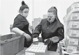  ?? TIMOTHY D. EASLEY/AP ?? An employee with the McKesson Corporatio­n scans a box of the Johnson and Johnson COVID-19 vaccine as she fills an order Monday at their shipping facility in Shepherdsv­ille, Kentucky.