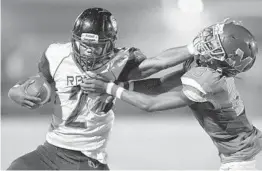  ?? MICHAEL LAUGHLIN/SUN SENTINEL ?? Palm Beach Lakes quarterbac­k Jalen Hall tries to get away from McArthur's Kevin Knowles during the first half of their game Friday night in Hollywood.