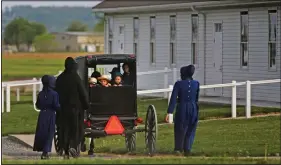  ?? (File Photo/AP/Jessie Wardarski) ?? Families of the Old Order Stauffer Mennonite Church in New Holland, Pa., arrive in May by horsedrawn buggy for their first in-person church service in nearly two months due to the coronaviru­s.