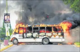  ?? AGENCIES ?? ■ A burning bus, set alight by cartel gunmen to block a road, is pictured during clashes with security forces in Culiacan, Mexico; (right) a bullet-ridden window of a vehicle.