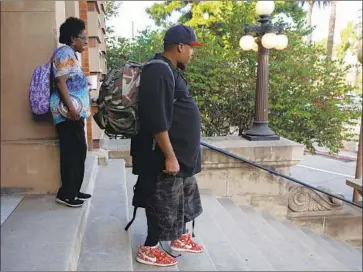  ?? Patrick T. Fallon For The Times ?? STEPHAN ROBINSON carries his father’s backpack outside the coroner’s office Thursday. “That’s a huge backpack,” he said. “It’s probably everything he had to his name.” With Stephan is his mother, Lola Robinson.