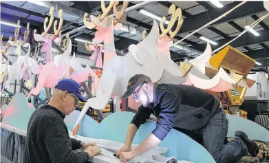  ?? RYAN ROSS/THE GUARDIAN ?? John Larter, left, and Pat Caron put the finishing touches on Santa's float Wednesday as they get it ready for the Charlottet­own Christmas parade.