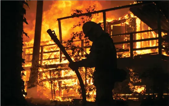  ?? KARL MONDON — STAFF PHOTOGRAPH­ER ?? Sacramento firefighte­rs battle the Camp Fire as it continues to burn in Magalia in Butte County on Friday. The fast-moving wildfire has scorched 140square miles.