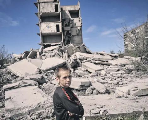  ?? ?? A young boy stands in front of a damaged building after a strike in Kramatorsk in the eastern Donbass region, Ukraine, May 25, 2022.