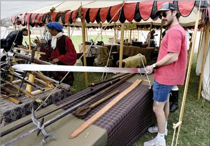  ?? CLIFF GRASSMICK — STAFF PHOTOGRAPH­ER ?? Austin Mcfarland finds the largest sword at the Colorado Tartan Day Festival at the Boulder County Fairground­s, 9595Nelson Road, on Saturday.