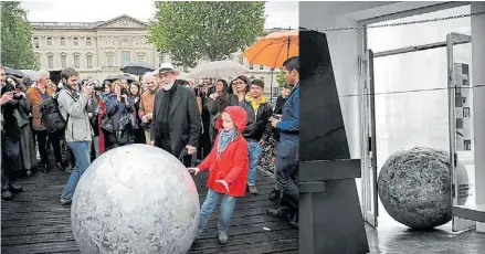  ??  ?? La obra y la gente. Pistoletto en la calle con su Sfera di Giornali, la esfera de periódicos que el público hace rodar desde 1967.