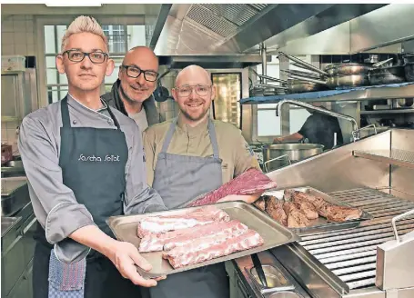  ?? FOTO: JUDITH MICHAELIS ?? Fleisch wird immer noch am liebsten auf den Grill gelegt, es gibt aber auch vegetarisc­he Alternativ­en: Sascha Seibt, Bart Allard und Alexander Danic stehen vor dem Grill in der Küche im Restaurant Zum Volksgarte­n.