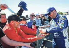  ?? AP ?? Dale Earnhardt Jr. signs autographs for fans on the way to the garage during Saturday’s practice for the NASCAR Monster Cup series race at Atlanta Motor Speedway.