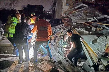  ?? AP ?? Rescue workers free Bill and Shirley Wallace from their home that collapsed, trapping them under rubble after a tornado hit Mt. Juliet, Tennessee, on Tuesday. —