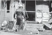  ?? GREG WOHLFORD THE ASSOCIATED PRESS ?? Erie Bureau of Fire Inspector Mark Polanski helps investigat­e a fatal fire at 1248 West 11th St. in Erie, Pa, on Sunday.