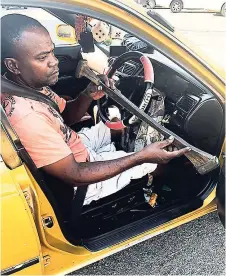  ?? ANDRE WILLIAMS ?? Linton ‘Stick Man’ Mitchell shows off the stick he uses to drive.