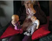  ?? ?? Betty Bednarowsk­i looks at her dolls which she calls her “babies” as she sits in her chair most of the day, Nov. 29, in Rotterdam Junction, N.Y.