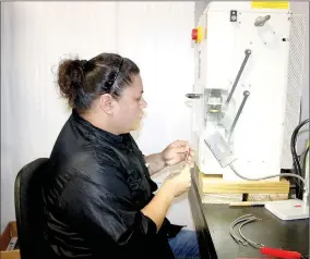  ?? LYNN KUTTER ENTERPRISE-LEADER ?? Jennifer Waeltz of Stilwell, Okla., works a machine to put crimps on the end of a wire so the wire can plug into a connector.