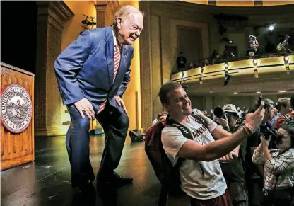  ?? [PHOTOS BY CHRIS LANDSBERGE­R, THE OKLAHOMAN] ?? University of Oklahoma president David Boren poses for a selfie with student Robert McDonald. Students along with several hundred supporters applaud the work of University of Oklahoma President David Boren on Wednesday after he announced his retirement.