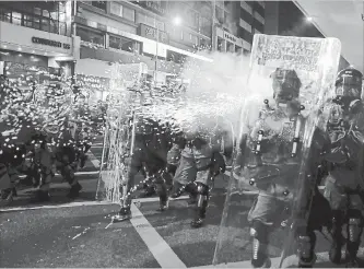  ?? VINCENT YU THE ASSOCIATED PRESS ?? Riot police fire tear gas at protesters during a protest against police brutality in Hong Kong on Sunday.