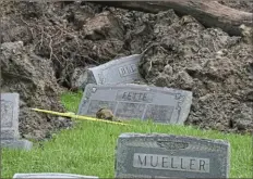  ?? ?? Gravestone­s ripped out by the landslide ended up on the edge of the debris field at the Wheeling Mt. Zion Cemetery.