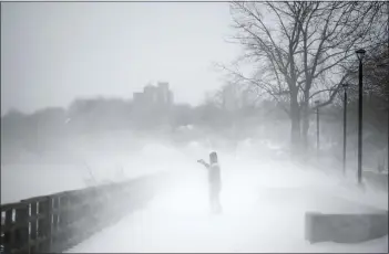  ?? VINCENT ALBAN — THE NEW YORK TIMES ?? Doug Alp photograph­s the wind and snow at Ontario Beach Park in Rochester, N.Y., on Friday.