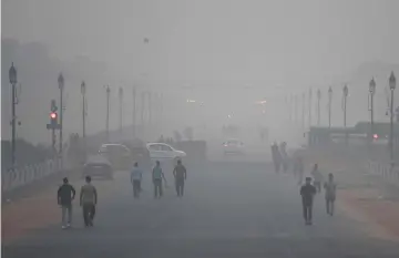  ??  ?? Indian pedestrian­s walk amid heavy smog conditions in New Delhi. — AFP photo