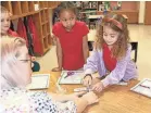  ?? PROVIDED BY KAVITHA CARDOZA/THE HECHINGER REPORT ?? Jackie Noble, a former bus driver and current paraprofes­sional, works on a science experiment with first graders at Brusly Elementary School in West Baton Rouge Parish, La.