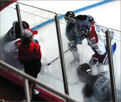  ?? ERNEST A. BROWN PHOTO/THE CALL ?? A young hockey fan watches the action on the ice through the glass during Mount Saint Charles new U15 team’s debut at Adelard Arena Saturday afternoon. Mount has always been synonymous with hockey greatness in Rhode Island but the school took it up a notch Saturday with the season openers for its four academy teams. Some of the top Division I prospects squared off for the first time, with Mount nearly pulling off the sweep.