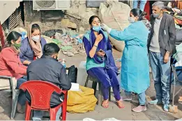  ?? PTI ?? A health worker collects swab sample of a woman for Covid-19 test, in the wake of recent surge in Coronaviru­s cases, in Jammu on Sunday. —