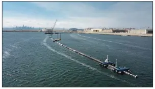  ?? AP ?? A long floating boom, intended to collect plastic litter in the Pacific Ocean, is assembled last month in Alameda, Calif., in this photo provided by The Ocean Cleanup.