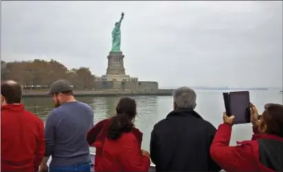  ?? ASSOCIATED PRESS FILE ?? Visitors view the Statue of Liberty during a been at the heart of the American ideal. ferry ride to Liberty Island, in New York. Immigratio­n has always