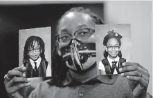  ?? [ROGELIO V. SOLIS/ASSOCIATED PRESS FILE PHOTO] ?? In this Oct. 27 photo, Sheldon Smith, center, holds the photograph­s of his children Deshawn Smith, 11, left, and Trinitee Smith, 13, both suffering from sickle cell anemia, during an Initiative 65 rally in Ridgeland, Miss.