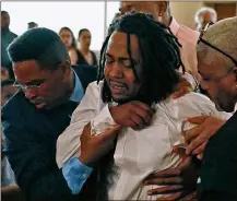  ?? BILL LACKEY / DAYTON DAILY NEWS ?? Dion Green is helped up after he collapsed during the funeral service for his father, Derrick Fudge, who died in his arms during the mass shooting in Dayton last weekend.