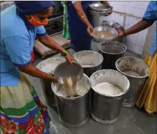  ??  ?? Staff members of Shri Mahila Griha Udyog mix ingredient­s and spices to make papadum dough.